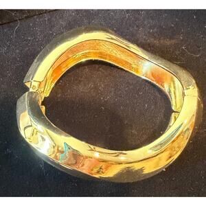 Chunky gold hinged bangle, polished metallic finish, wave silhouette size 7.25”